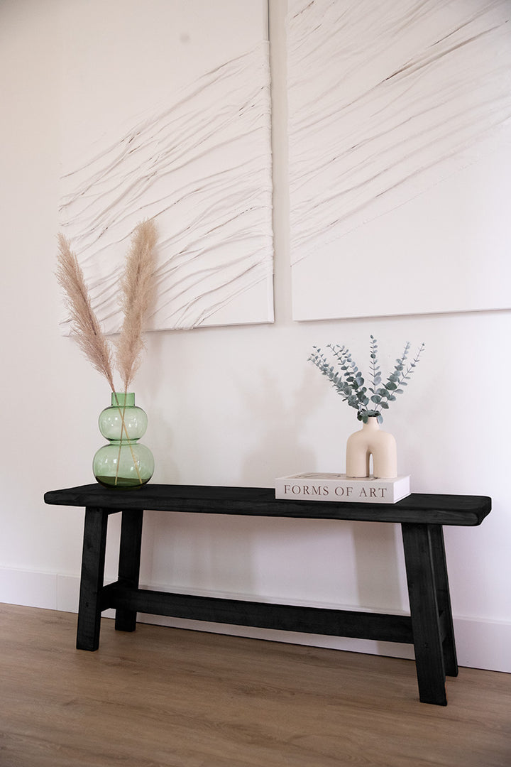 Stijlvol houten bankje in de kleur zwart, geschikt om op te zitten of accessoires op te leggen