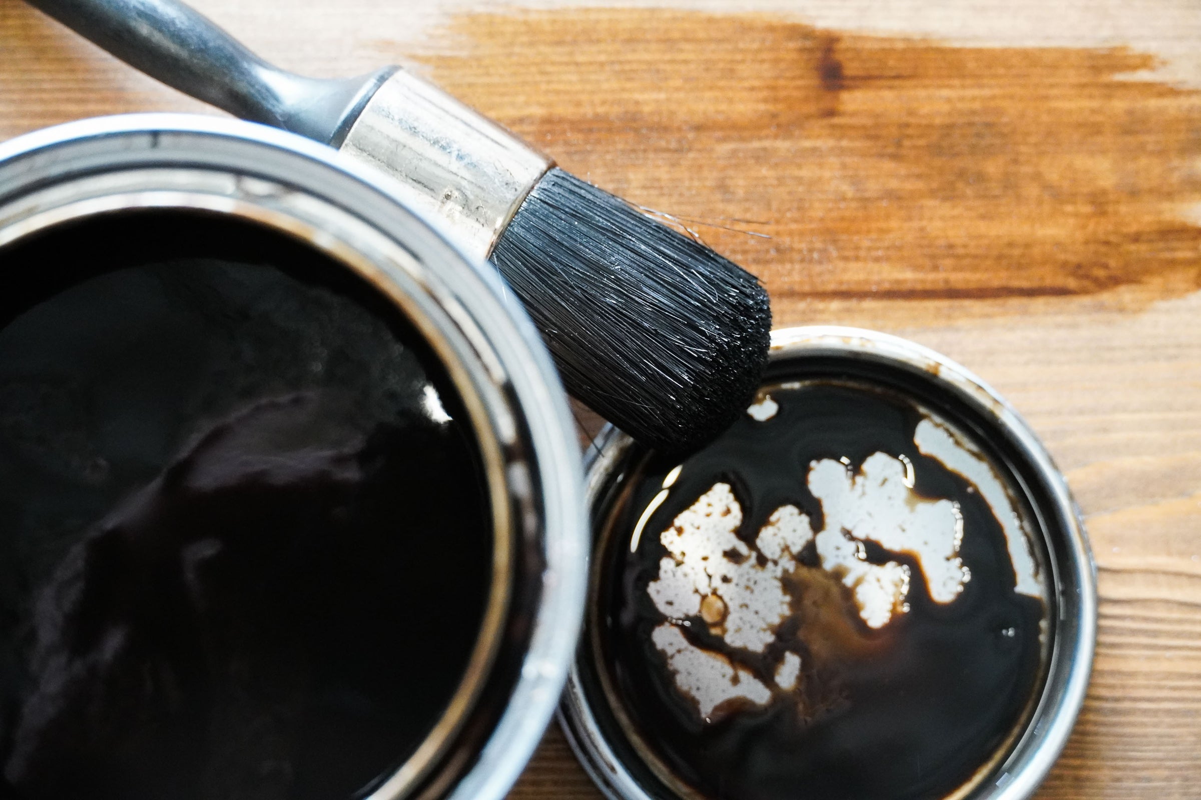 Beits en een kwast van Baan Woods liggend op een houten plank