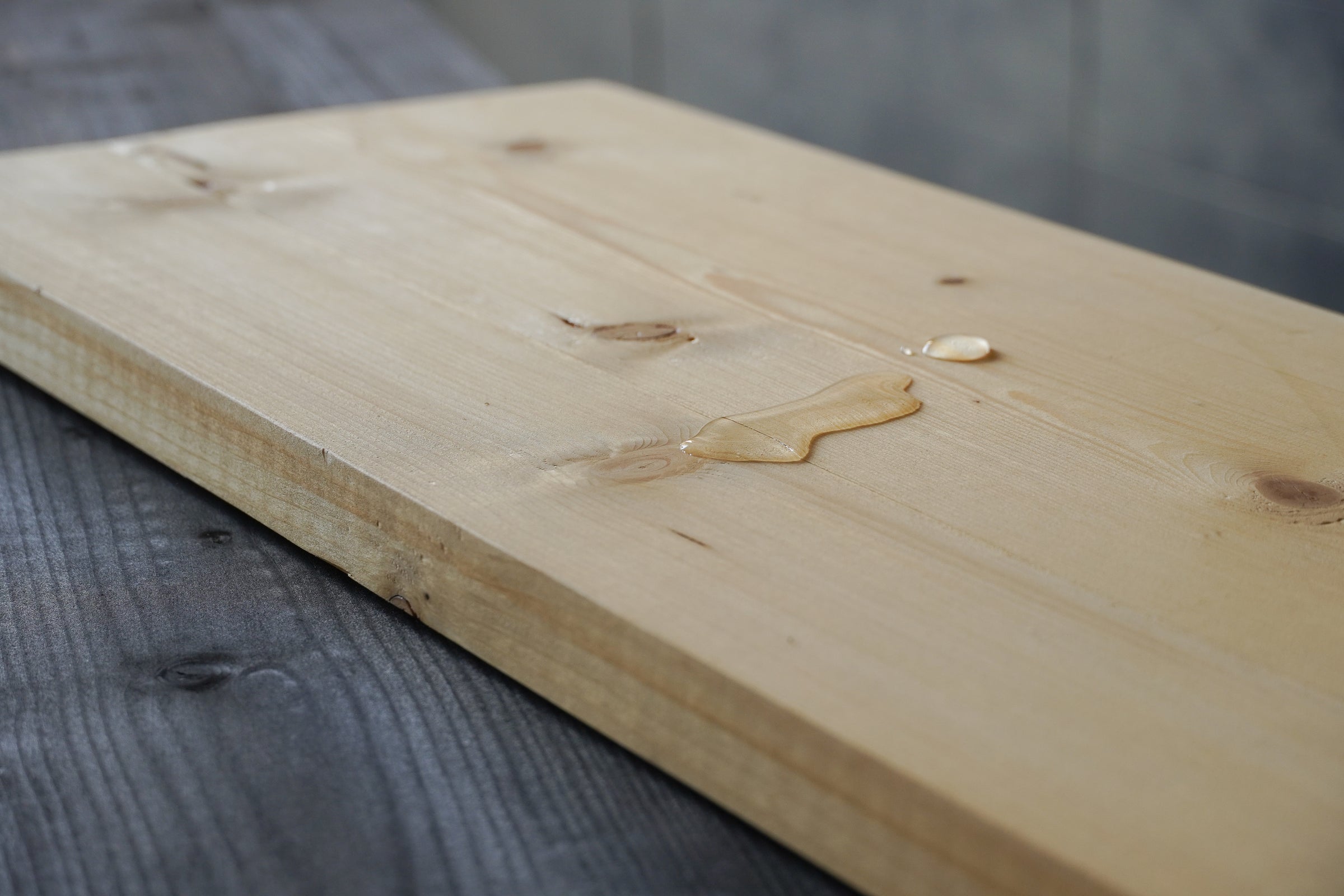 Waterdruppels op waterafstotende plank van Baan Woods