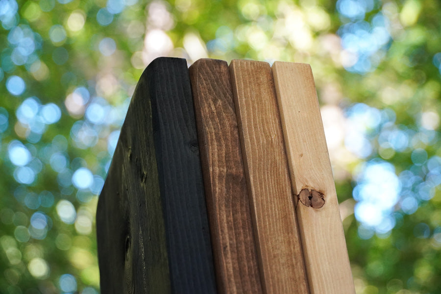 Vier houten kleurstalen van Baan Woods: lichtbruin, middenbruin, donkerbruin en zwart 