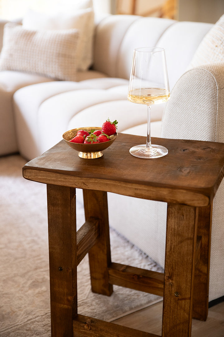 Donkerbruine houten kruk van Baan Woods gedecoreerd met een schaaltje aardbeien en een glas wijn