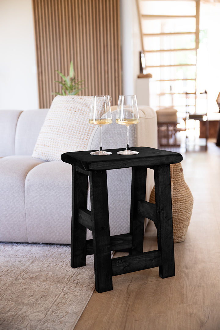 Zwarte houten kruk van Baan Woods in woonkamerinterieur 