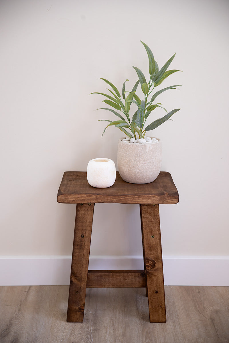 Decoratieve houten kruk met schuine poten, te gebruiken voor planten of woonaccessoires