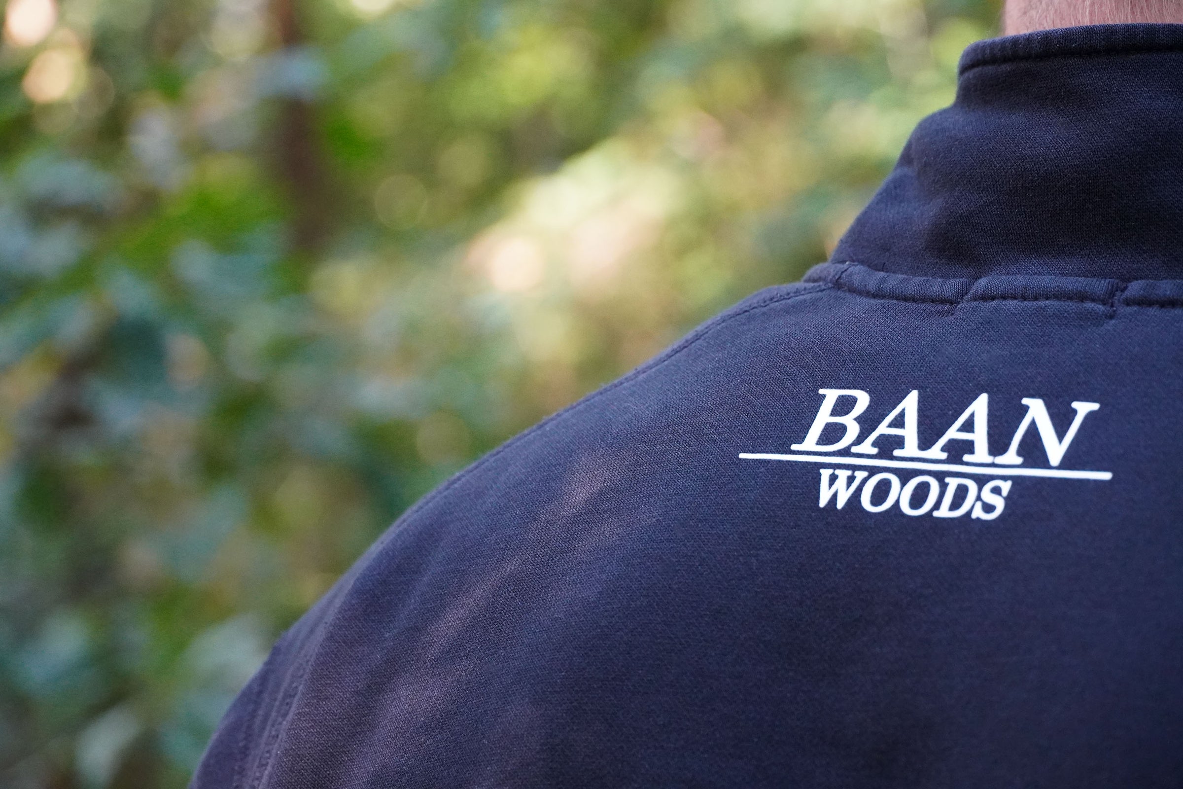 Baan Woods logo op een trui in de groene natuur