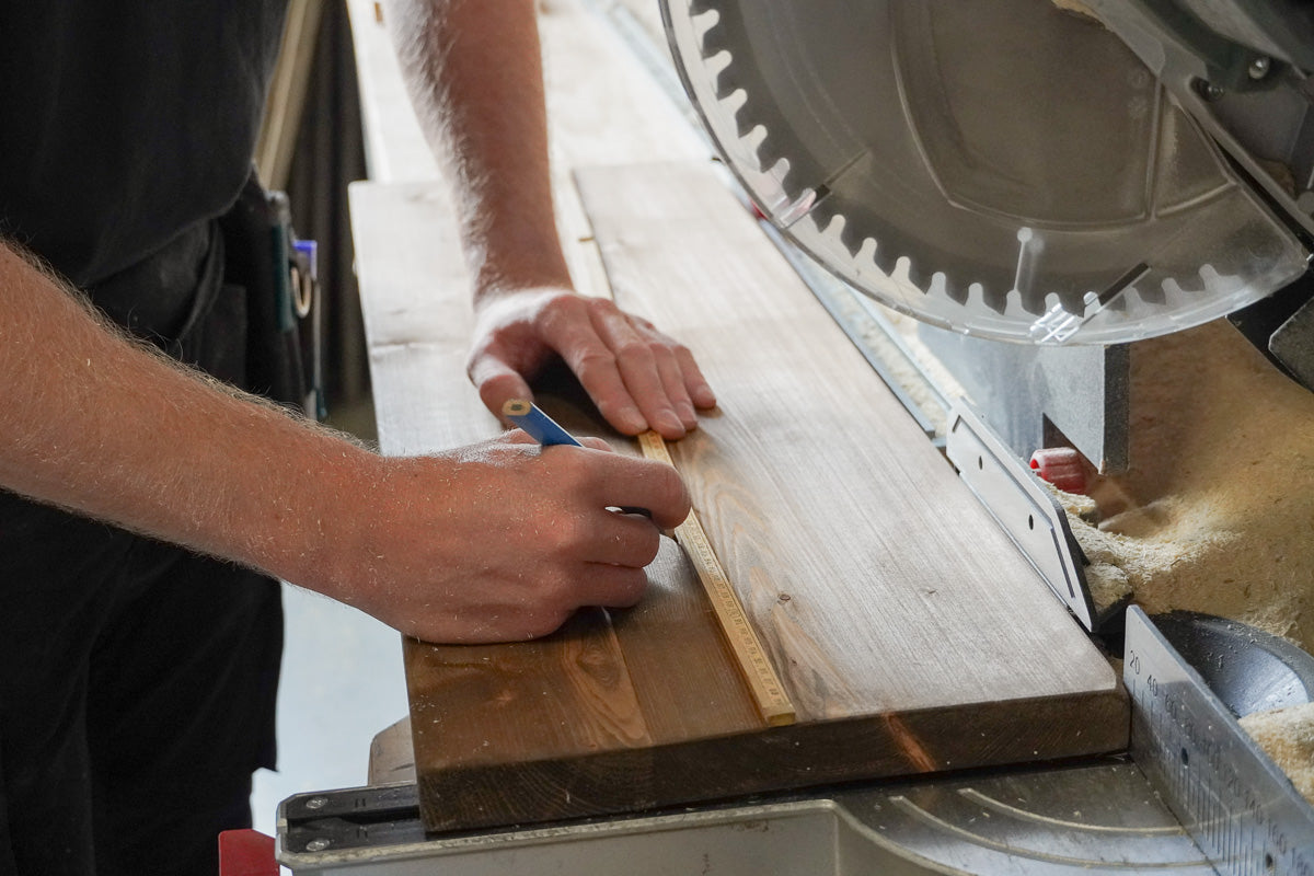 Een plank opmeten in de werkplaats van Baan Woods