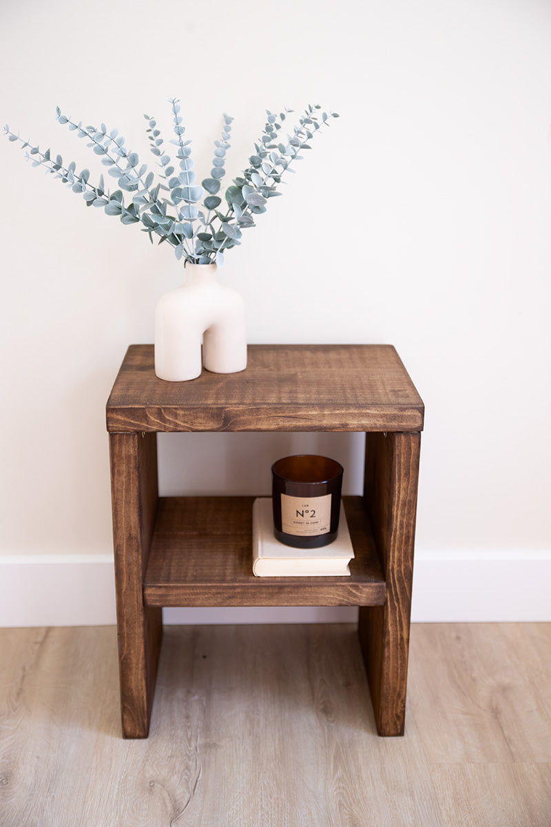 Functioneel houten meubelstuk dat dienstdoet als nachtkastje en bijzettafeltje