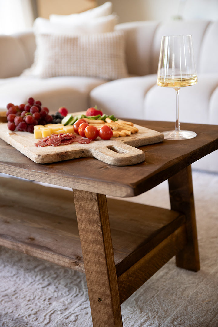 Salontafel van Baan Woods, gedecoreerd met een hapjesplank en glas wijn