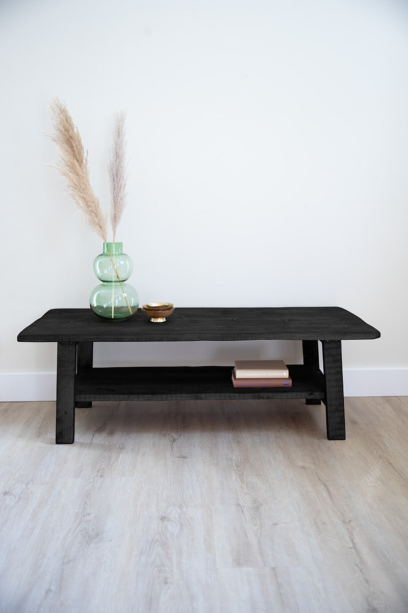 Lage zwarte houten salontafel met functionele plank voor spulletjes 