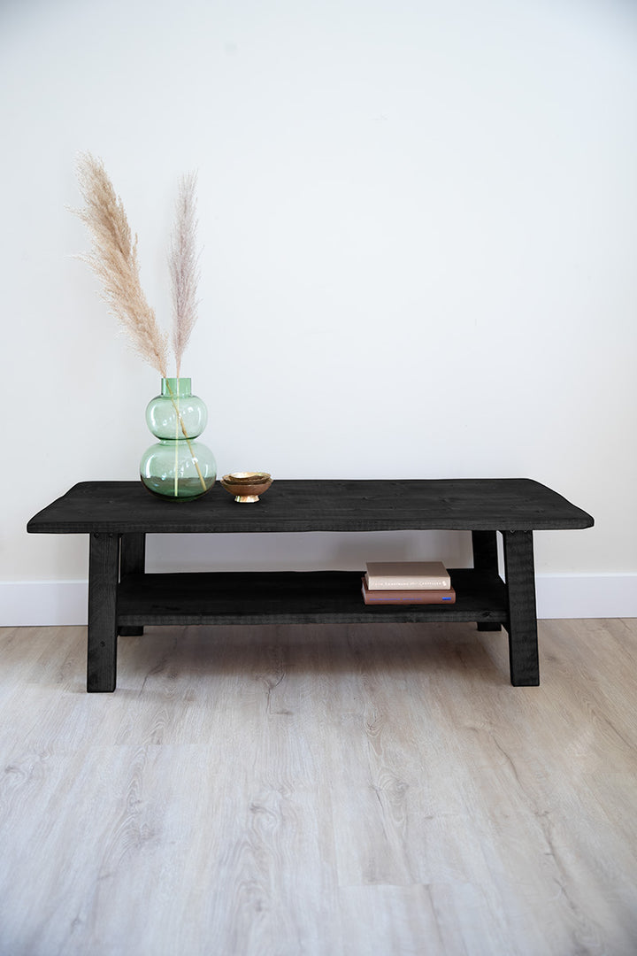 Lage zwarte houten salontafel met functionele plank voor spulletjes 