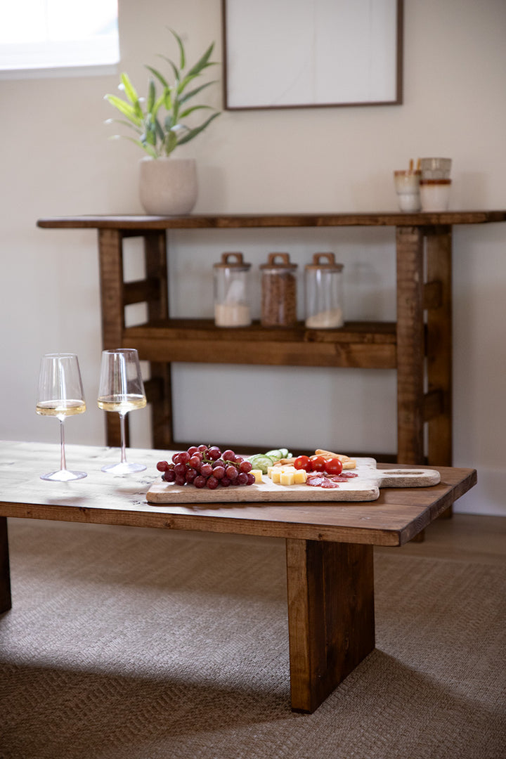 Salontafel Bliss in donkerbruin met een borrelplank en twee glazen wijn