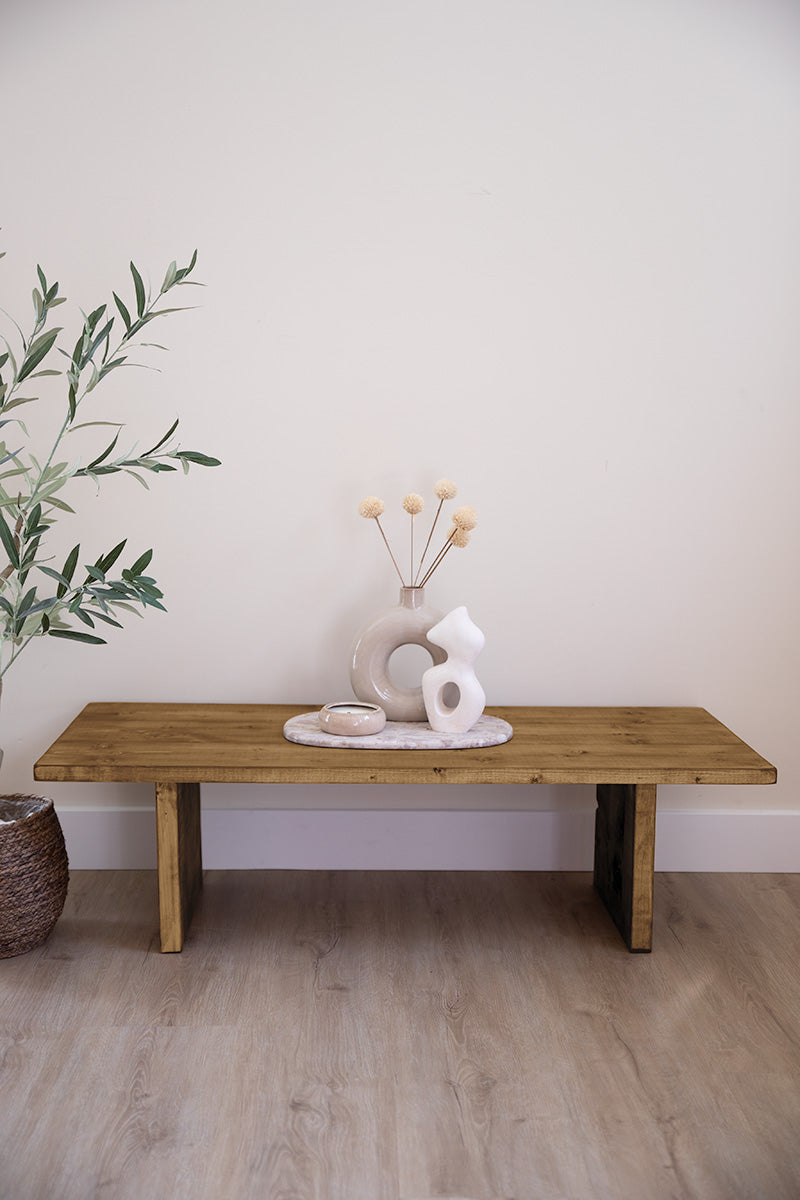 Middenbruin houten salontafel, gedecoreerd met vaasjes en een kaars