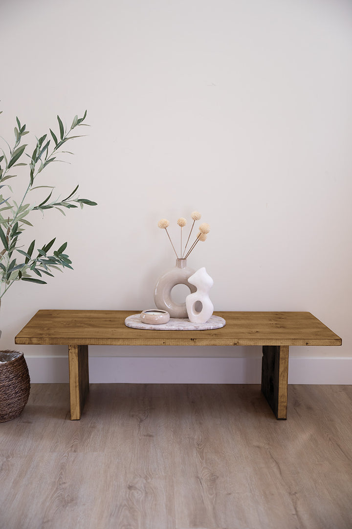 Middenbruin houten salontafel, gedecoreerd met vaasjes en een kaars