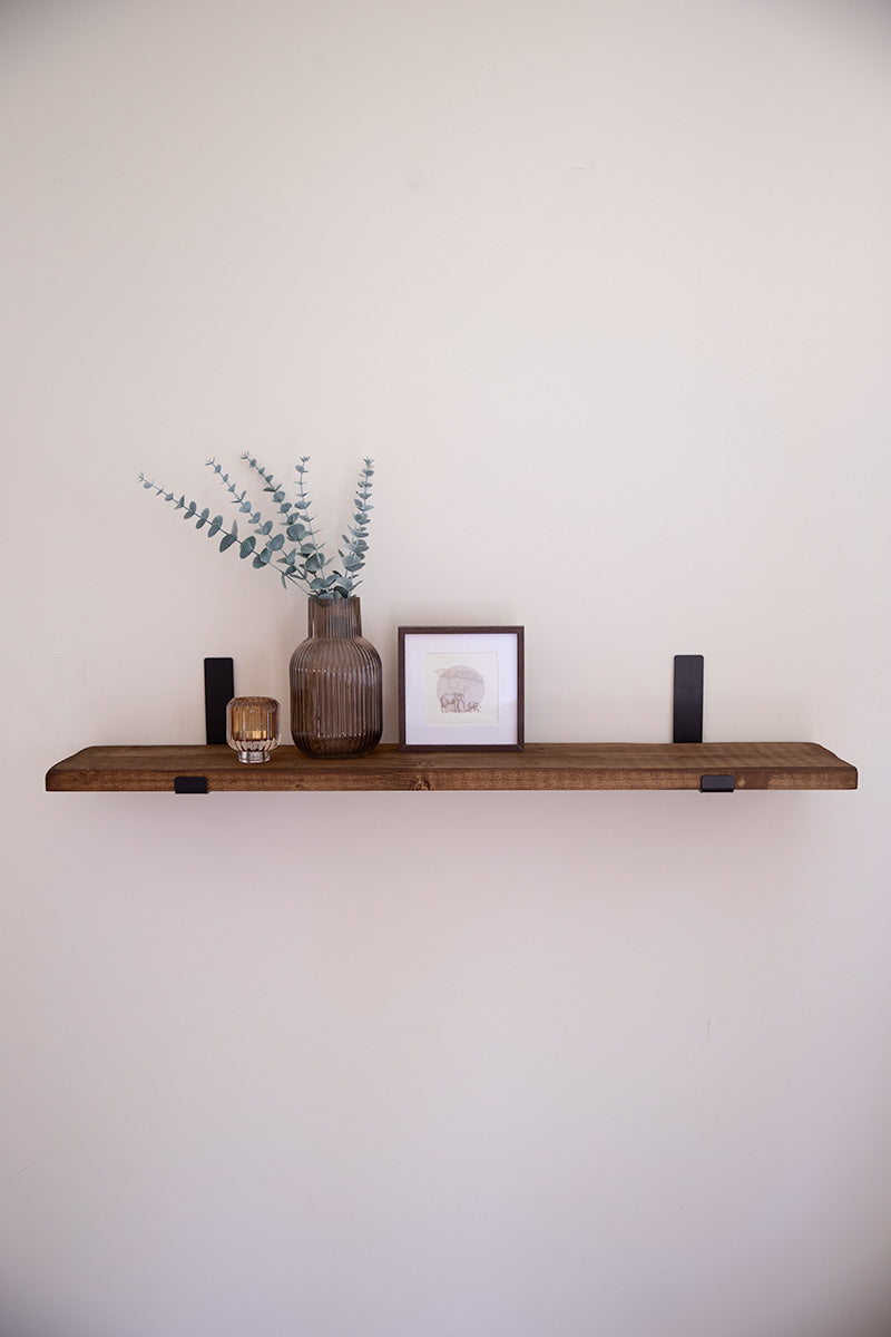 Donkerbruine houten wandplank van Baan Woods, bevestigd met twee stalen beugels