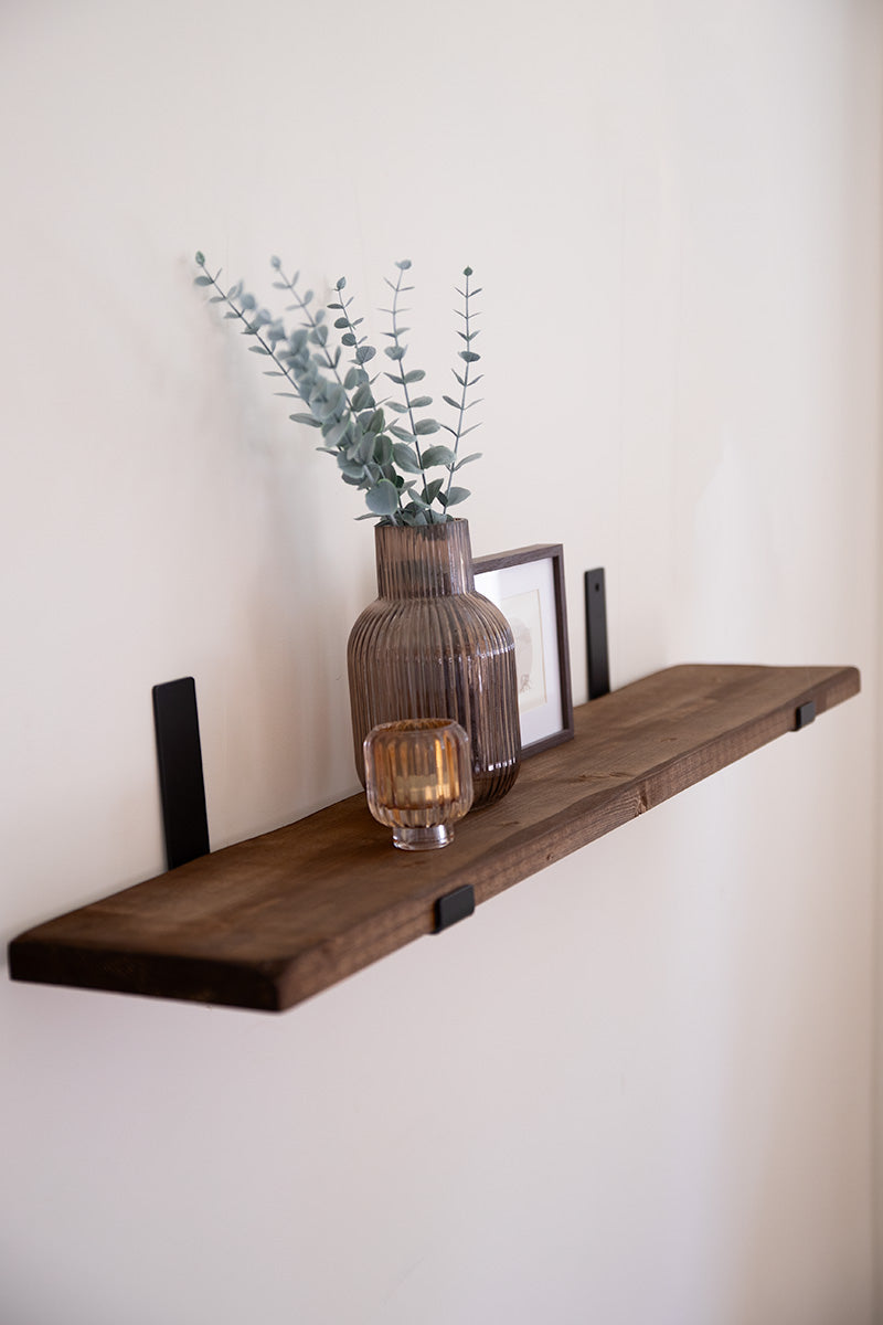 Houten wandplank in de kleur donkerbruin met zwarte stalen beugels