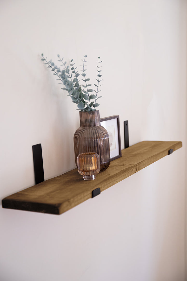 Houten wandplank van Baan Woods aan de muur bevestigd met robuuste stalen beugels