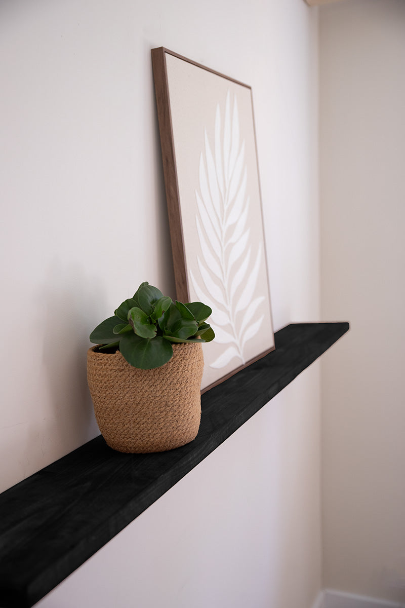 Houten wandplank in het zwart, lijkt te zweven door onzichtbare bevestiging